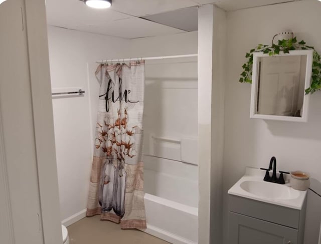 full bathroom with shower / bath combo, vanity, toilet, and a drop ceiling