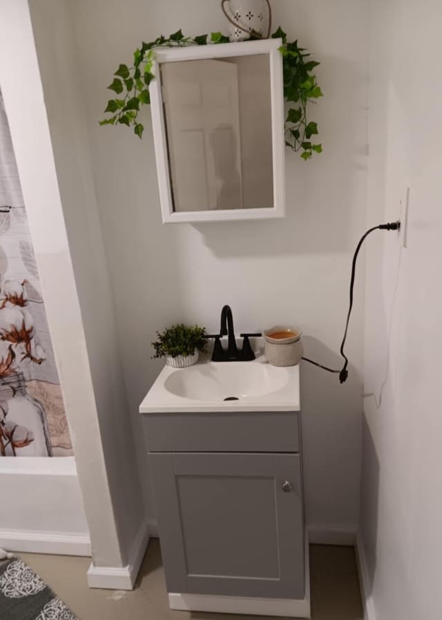 full bath with vanity and baseboards
