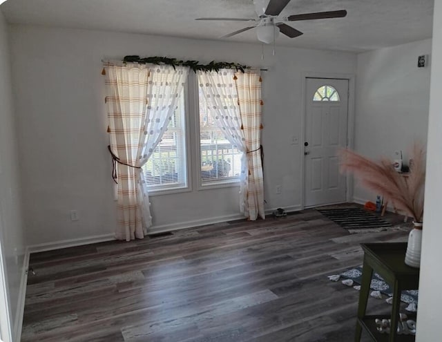 unfurnished dining area featuring a ceiling fan, baseboards, and wood finished floors