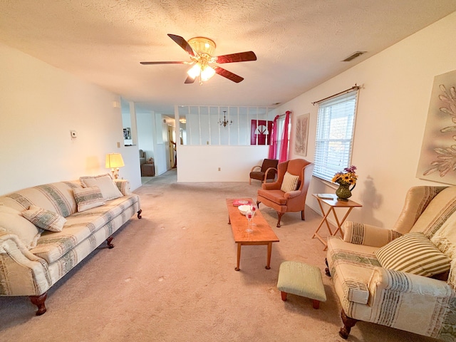 carpeted living room with ceiling fan and a textured ceiling