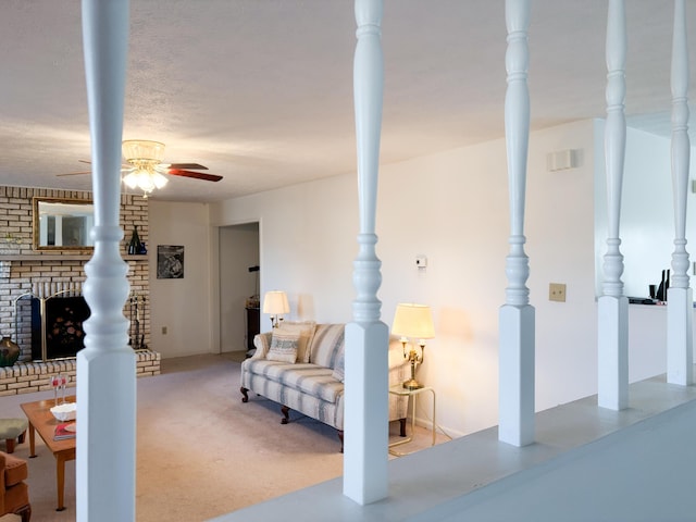 interior space with light carpet, a textured ceiling, ceiling fan, and a fireplace