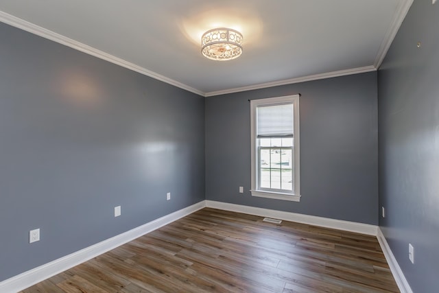 empty room featuring baseboards, crown molding, visible vents, and dark wood-style flooring