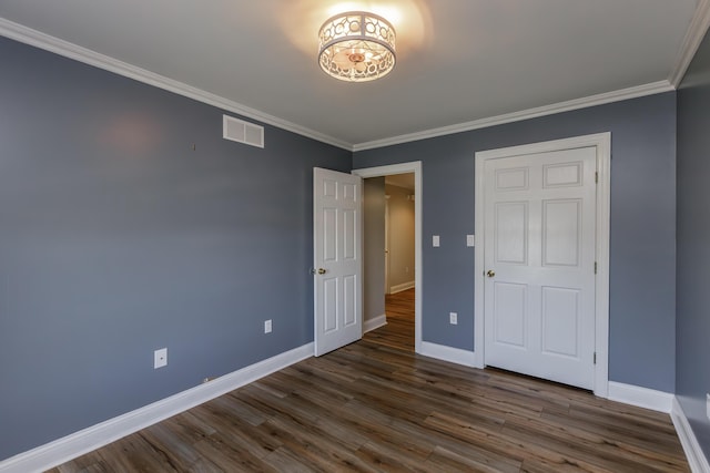 unfurnished bedroom featuring baseboards, crown molding, visible vents, and dark wood-type flooring