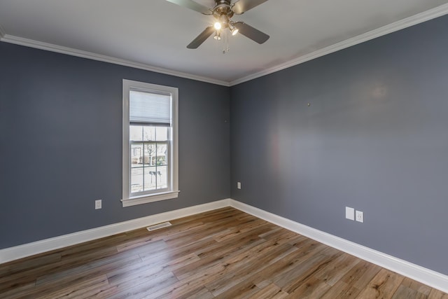 spare room with baseboards, visible vents, and wood finished floors