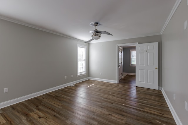 empty room featuring ornamental molding, ceiling fan, dark wood-type flooring, and baseboards