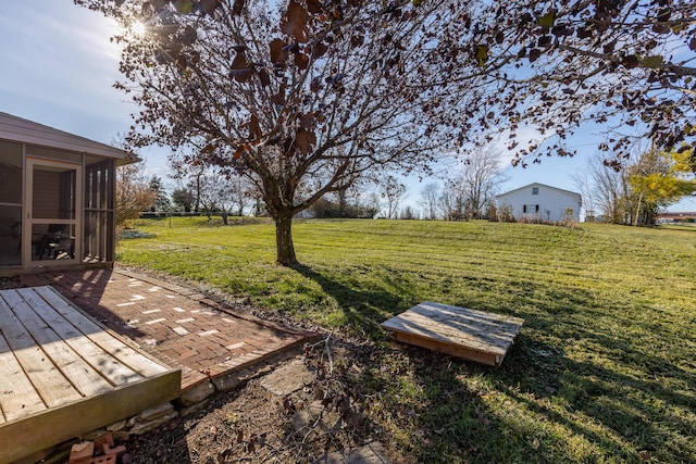 view of yard featuring a rural view and a sunroom