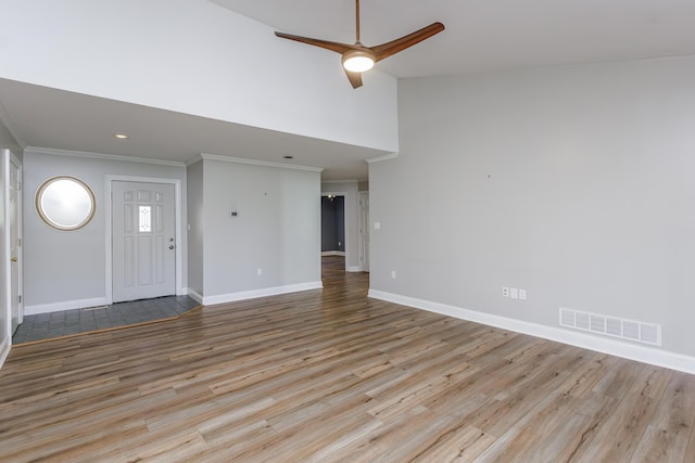 unfurnished living room with light wood finished floors, baseboards, visible vents, ceiling fan, and ornamental molding