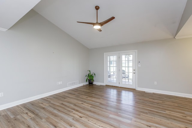 empty room featuring lofted ceiling, baseboards, visible vents, and light wood-style floors