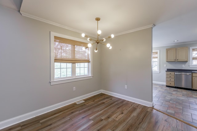 unfurnished dining area featuring baseboards, visible vents, wood finished floors, crown molding, and a healthy amount of sunlight