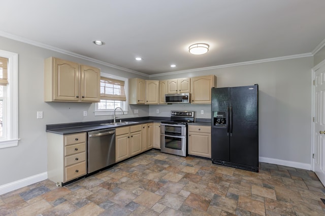 kitchen featuring crown molding, stainless steel appliances, dark countertops, a sink, and baseboards