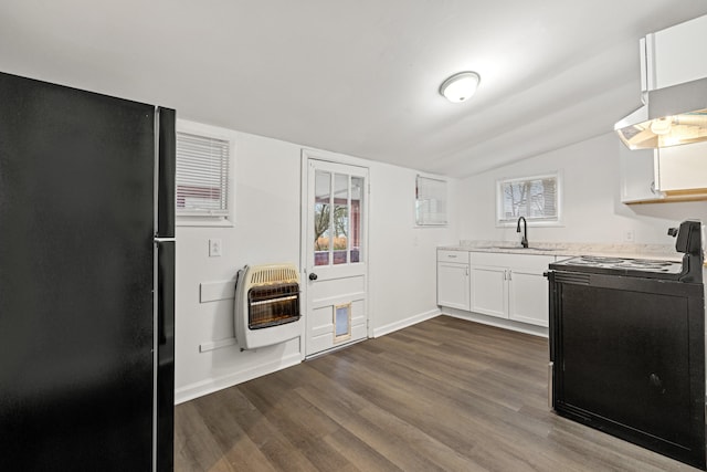 kitchen with white cabinetry, range with electric cooktop, black fridge, heating unit, and vaulted ceiling