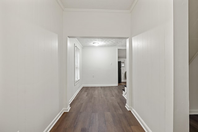 hall with wood walls, dark hardwood / wood-style flooring, crown molding, and a textured ceiling