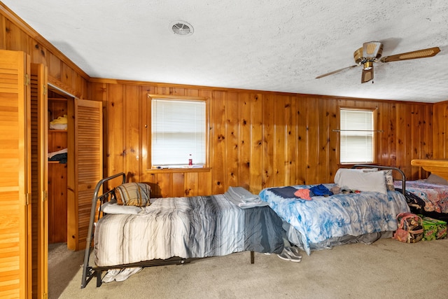 bedroom featuring ceiling fan, carpet floors, and a textured ceiling