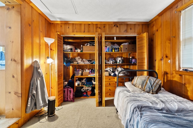 carpeted bedroom with wood walls and ornamental molding