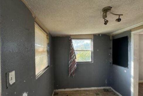 unfurnished room with a textured ceiling