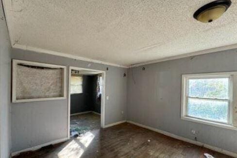 unfurnished room featuring a textured ceiling and dark wood-type flooring