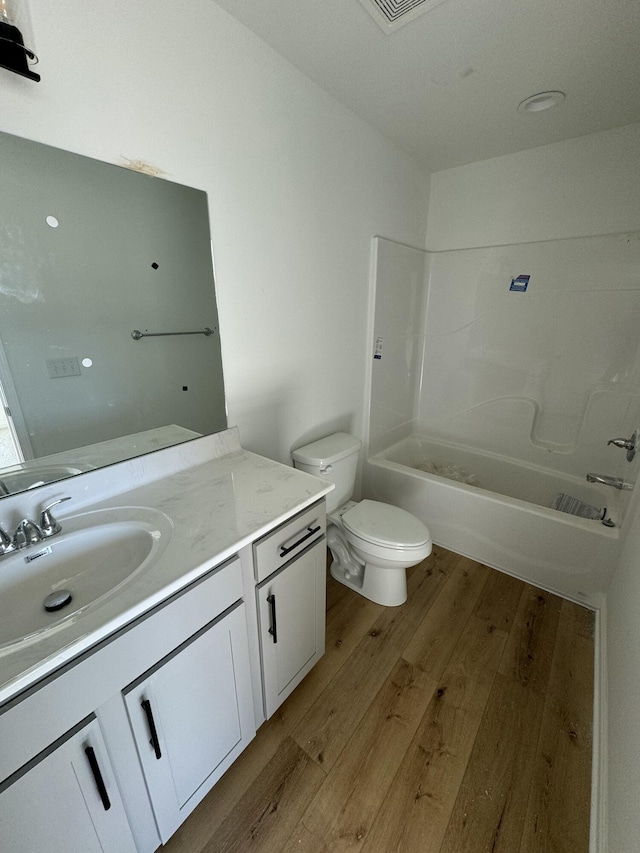 full bathroom featuring shower / tub combination, vanity, hardwood / wood-style flooring, and toilet