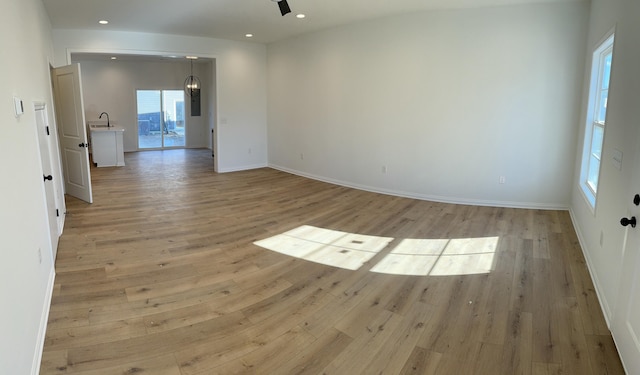 spare room featuring sink and light hardwood / wood-style floors