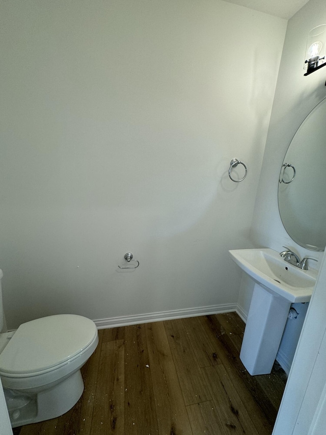 bathroom with hardwood / wood-style floors and toilet