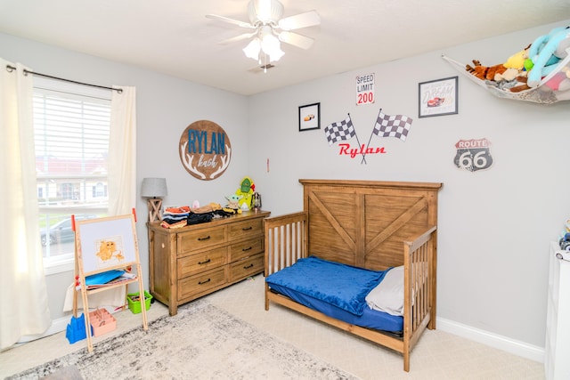 bedroom with light carpet, ceiling fan, and baseboards