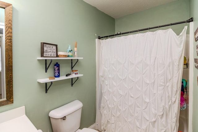 bathroom featuring toilet, curtained shower, a textured ceiling, and vanity