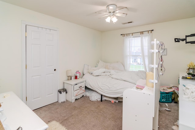 bedroom featuring a ceiling fan, light colored carpet, and visible vents