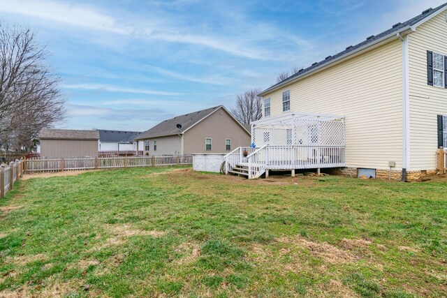 rear view of property with a deck, a yard, and a fenced backyard