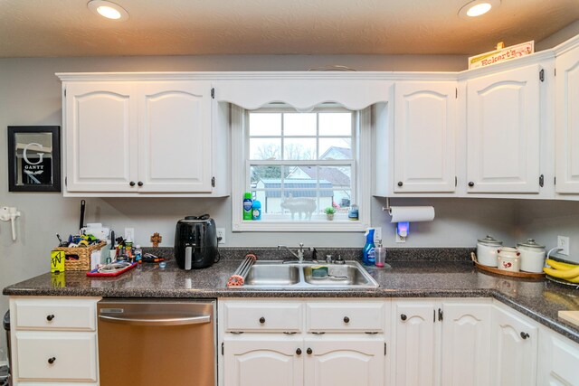 kitchen featuring recessed lighting, white cabinets, a sink, and stainless steel dishwasher