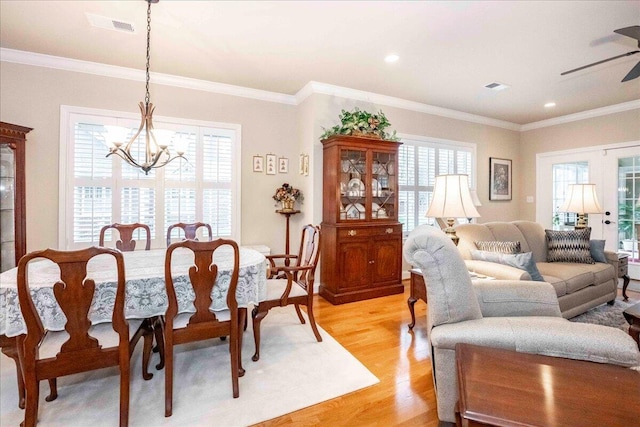 dining room featuring ceiling fan with notable chandelier, ornamental molding, and light hardwood / wood-style flooring