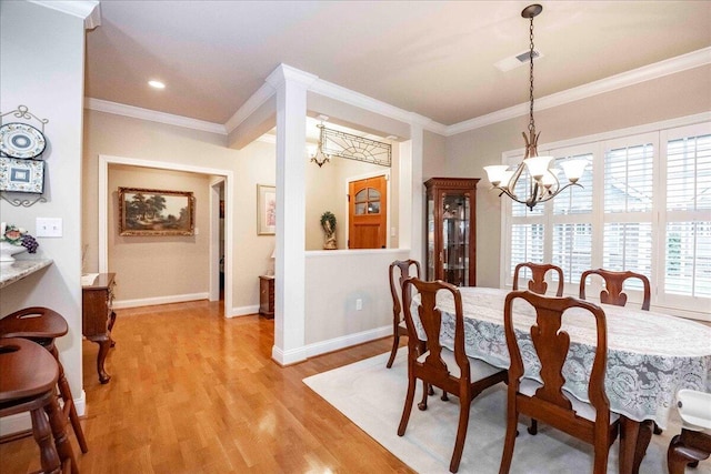 dining room with crown molding, light hardwood / wood-style flooring, and a notable chandelier