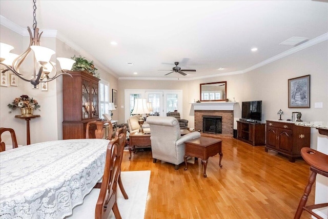 dining room featuring crown molding, light hardwood / wood-style flooring, and ceiling fan with notable chandelier