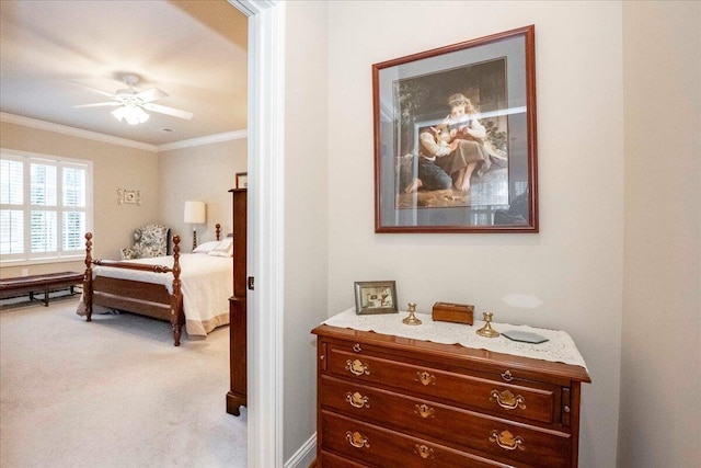 carpeted bedroom with ceiling fan and ornamental molding