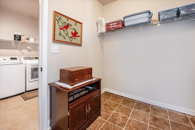 washroom with dark tile patterned flooring and washing machine and dryer