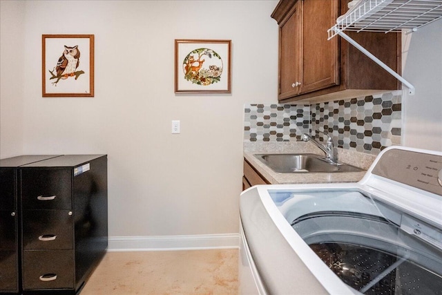 clothes washing area with cabinets, washer / clothes dryer, and sink