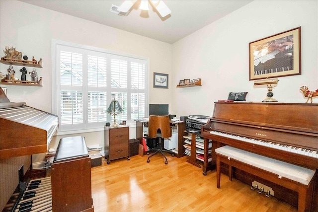 office with light hardwood / wood-style flooring and ceiling fan