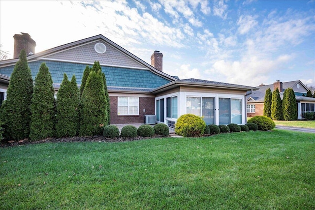 view of front facade featuring cooling unit and a front lawn