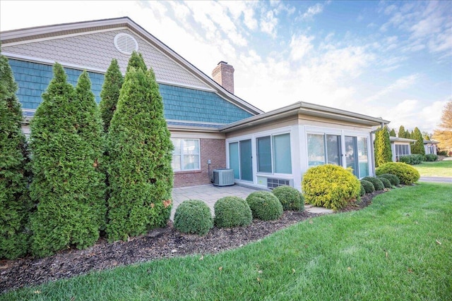 back of property featuring a patio, central AC, and a lawn