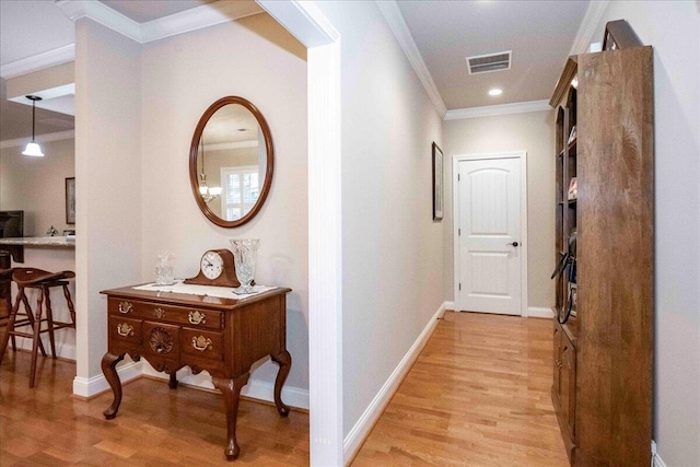 hallway with crown molding and light hardwood / wood-style flooring