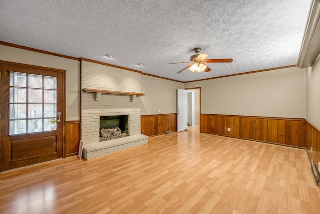 unfurnished living room featuring a textured ceiling, light hardwood / wood-style flooring, and ornamental molding