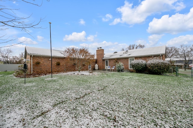 rear view of house featuring a lawn and a patio