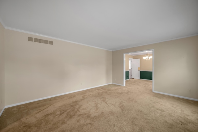 spare room with light carpet, a chandelier, and ornamental molding