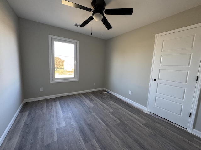 empty room with dark hardwood / wood-style floors and ceiling fan