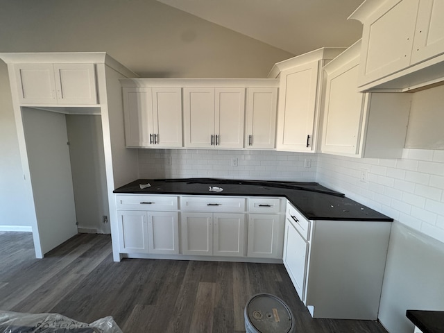 kitchen with white cabinets, tasteful backsplash, dark wood-type flooring, and vaulted ceiling