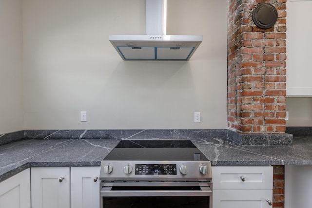 kitchen with white cabinets, island range hood, dark stone countertops, and electric stove