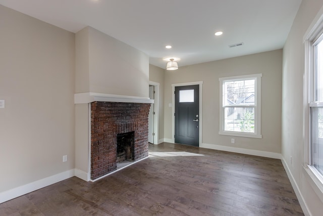 entryway featuring a fireplace and dark hardwood / wood-style floors