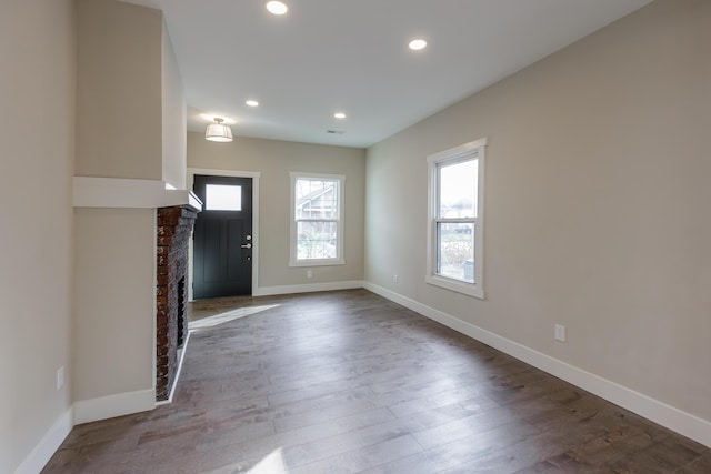 entryway with light hardwood / wood-style floors and a fireplace