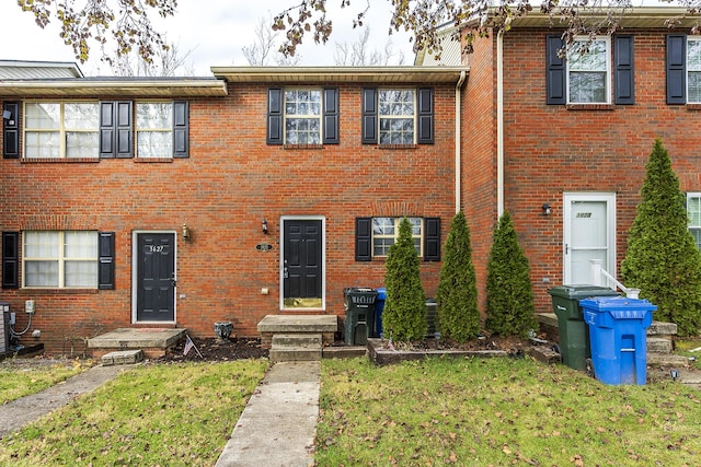 view of property with a front lawn and central AC unit