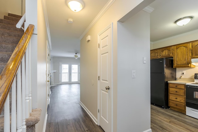 hallway featuring dark hardwood / wood-style floors, ornamental molding, and french doors