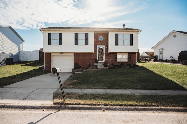 split foyer home with a garage and a front lawn