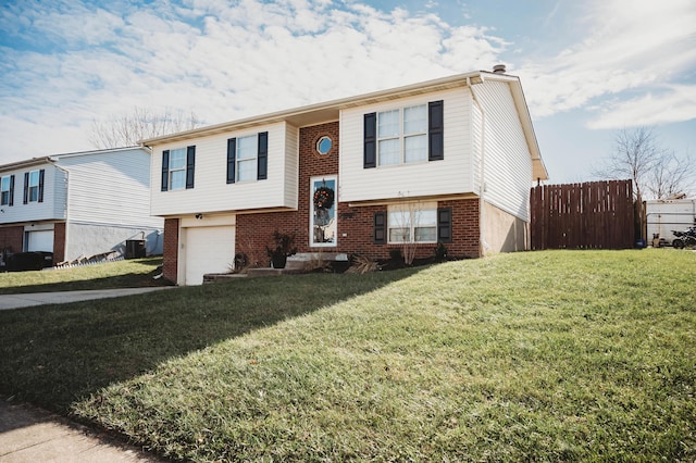 bi-level home with a front yard, a garage, and central air condition unit